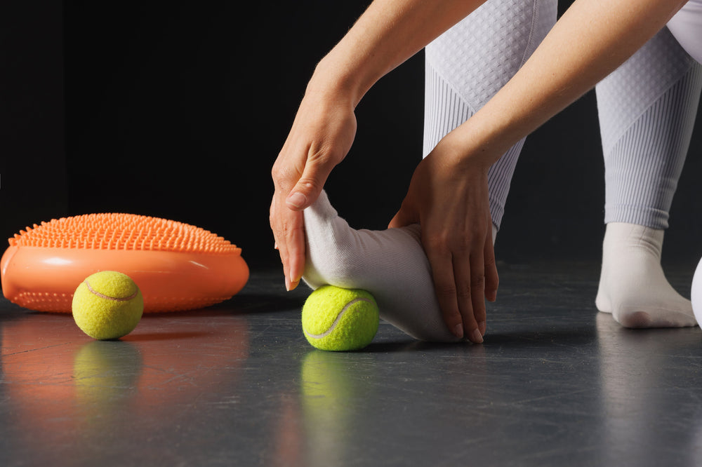 Exercise your feet using a tennis ball